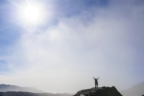 Indonesien, Java, Bromo Tengger Semeru National Park, Frau steht im Gegenlicht am Rande des Bromo-Kraters - RUNF00694