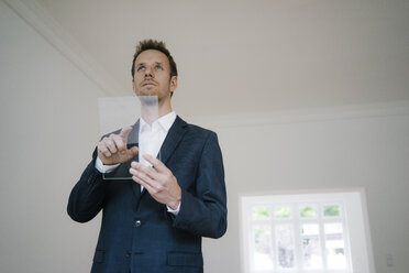 Geschäftsmann mit Glas-Touchscreen in einem neuen Haus - KNSF05473