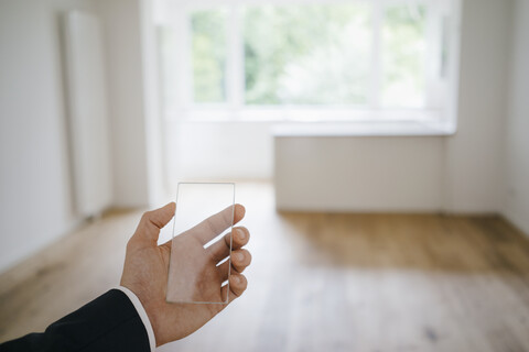 Hand hält Glas-Touchscreen in renoviertem Haus, lizenzfreies Stockfoto