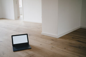 Laptop on wooden floor in a newly refurbished house - KNSF05481