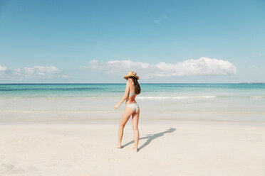 Spanien, Mallorca, Rückansicht einer jungen Frau im Urlaub am Strand stehend - LOTF00002