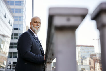 Elegant businessman leaning on railing in the city, looking at view - RHF02397