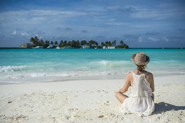 Maledives, Ari Atoll, Nalaguraidhoo, Sun Island Resort, back view of woman sitting on the beach - RUNF00730