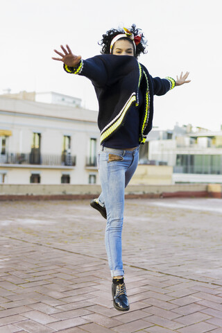 Porträt einer glücklichen jungen Frau beim Springen in der Stadt, lizenzfreies Stockfoto