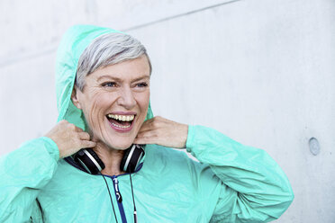 Porträt einer lachenden sportlichen reifen Frau mit Kopfhörern - VWF00036