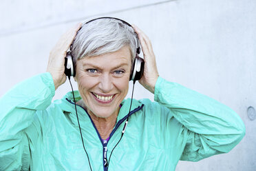 Portrait of smiling sporty mature woman with headphones - VWF00040