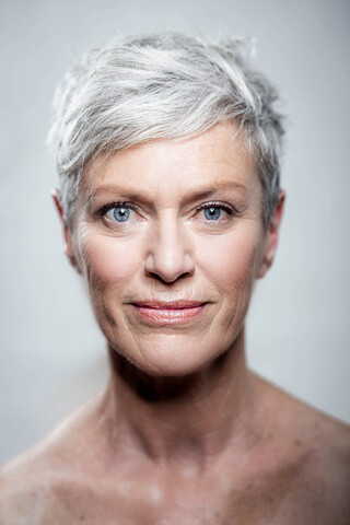 Porträt einer reifen Frau mit kurzen grauen Haaren und blauen Augen, lizenzfreies Stockfoto