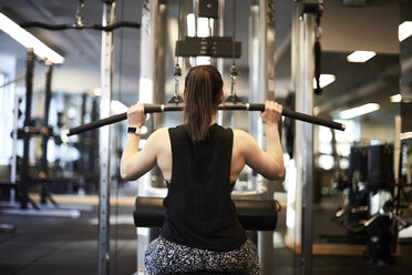 Frau trainiert mit Gerät im Fitnessstudio - AURF08106