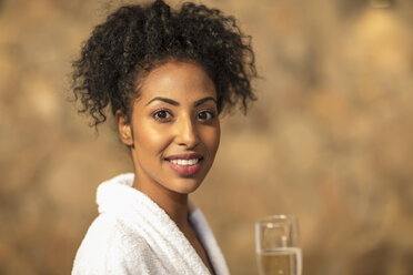 Porträt einer lächelnden jungen Frau, die ein Glas Champagner in einem Spa trinkt - ZEF16101