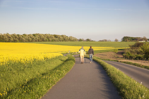 Deutschland, Rügen, Wanderer am Kap Arkona, Rapsfeld - MAMF00265