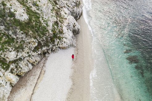 Italien, Elba, Frau mit rotem Mantel bei Strandspaziergang, Luftaufnahme mit Drohne - FBAF00219