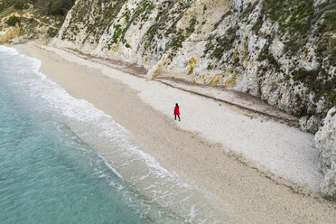 Italien, Elba, Frau mit rotem Mantel bei Strandspaziergang, Luftaufnahme mit Drohne - FBAF00220