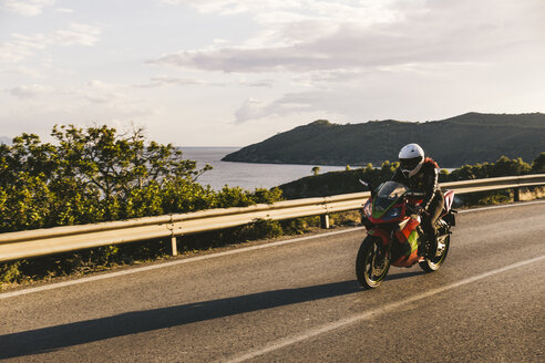 Italien, Insel Elba, Motorradfahrerin beim Biken - FBAF00226