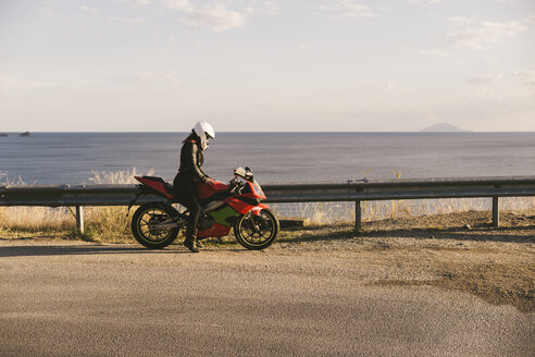 Italien, Insel Elba, Motorradfahrerin am Aussichtspunkt - FBAF00231