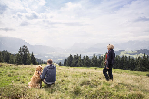 Österreich, Tirol, Kaisergebirge, Mutter und erwachsener Sohn mit Hund auf einer Wanderung in den Bergen - MAMF00279