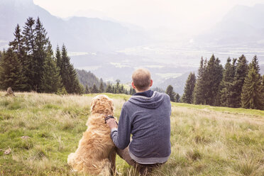 Österreich, Tirol, Kaisergebirge, Mann mit Hund beim Wandern in den Bergen - MAMF00280