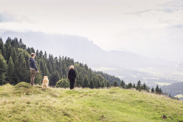 Österreich, Tirol, Kaisergebirge, Mutter und erwachsener Sohn mit Hund auf einer Wanderung in den Bergen - MAMF00281