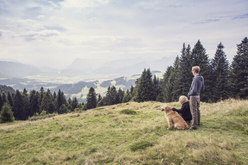 Österreich, Tirol, Kaisergebirge, Mutter und erwachsener Sohn mit Hund auf einer Wanderung in den Bergen - MAMF00282