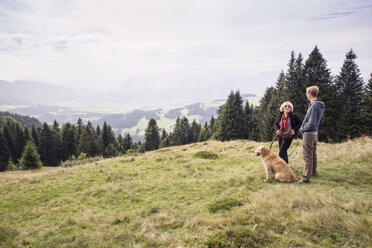 Österreich, Tirol, Kaisergebirge, Mutter und erwachsener Sohn mit Hund auf einer Wanderung in den Bergen - MAMF00283