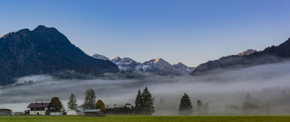 Germany, Bavaria, Upper Allgaeu, Loretto meadows near Oberstdorf with morning fog and mountains in background - WGF01285