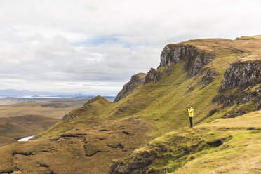 UK, Schottland, Isle of Skye, Quiraing, Fotograf auf einer Klippe beim Fotografieren - WPEF01230