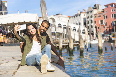 Italy, Venice, couple relaxing and taking a selfie with Rialto bridge in background - WPEF01241