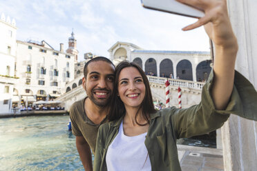 Italy, Venice, couple enjoying the city and taking a selfie with Rialto bridge in background - WPEF01246