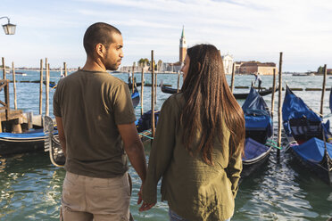 Italien, Venedig, verliebtes junges Paar mit Gondelbooten im Hintergrund - WPEF01249