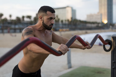 Muskulöser Mann mit nacktem Oberkörper beim Workout im Freien - MAUF02212