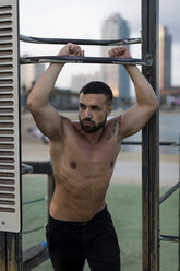 Muskulöser Mann mit nacktem Oberkörper, der eine Pause vom Training im Freien macht - MAUF02216