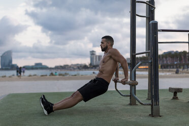 Muskulöser Mann mit nacktem Oberkörper beim Workout im Freien - MAUF02222