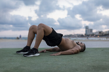 Muskulöser Mann mit nacktem Oberkörper beim Workout im Freien - MAUF02226