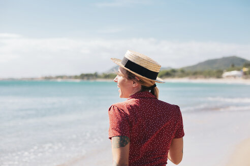 Spain, Mallorca, back view of happy young woman with tattoos on the beach - LOTF00014