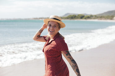 Spain, Mallorca, portrait of happy young woman with tattoos on the beach - LOTF00017