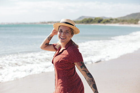 Spain, Mallorca, portrait of happy young woman with tattoos on the beach - LOTF00017