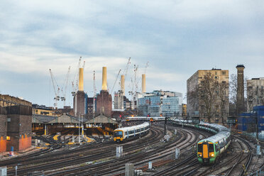 Vereinigtes Königreich, England, London, Blick auf Eisenbahnschienen und Züge am Abend, im Hintergrund das ehemalige Kraftwerk Battersea und Kräne - WPEF01262