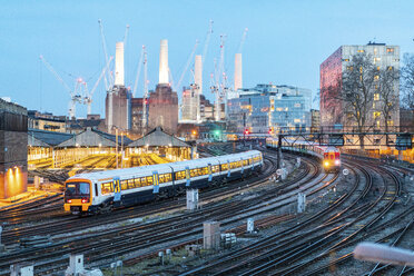 United Kingdom, England, London, view of railtracks and trains in the evening, former Battersea Power Station and cranes in the background - WPEF01263