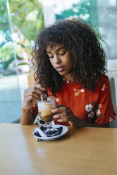 Porträt einer jungen Frau beim Kaffeetrinken in einem Café - KIJF02135