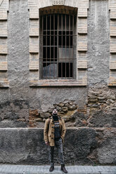 Spanien, Igualada, Mann steht vor einem heruntergekommenen Industriegebäude in der Stadt - JRFF02283