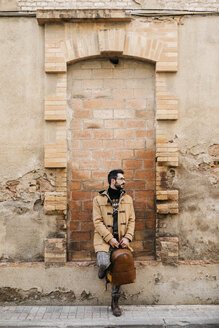 Spanien, Igualada, Mann mit Rucksack vor einem verfallenen Gebäude - JRFF02292