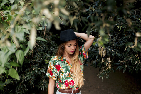 Blond young woman surrounded by leaves and nature stock photo