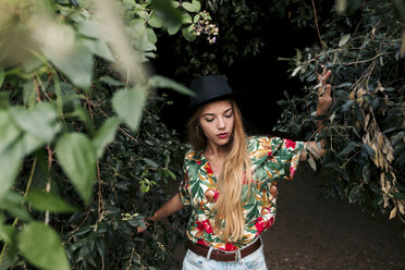 Blonde junge Frau umgeben von Blättern und Natur - LOTF00027