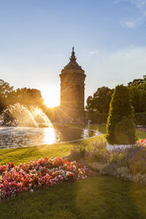 Germany, Mannheim, Friedrichsplatz with fountain and water tower in the background by sunset - WDF05012