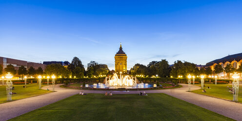 Germany, Mannheim, Friedrichsplatz with fountain and water tower in the background at blue hour - WDF05013