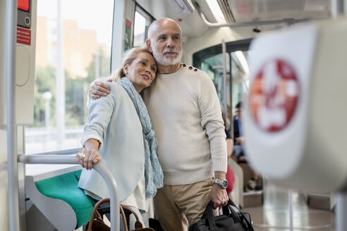 Zärtliches älteres Paar in einer Straßenbahn stehend - MAUF02245