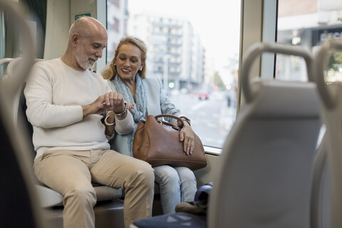 Älteres Ehepaar in der Straßenbahn, das die Zeit überprüft, lizenzfreies Stockfoto