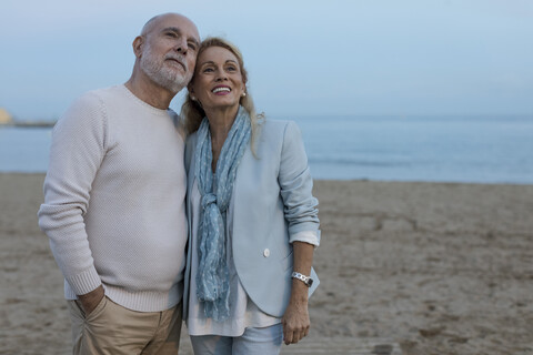 Spain, Barcelona, happy senior couple on the beach at dusk stock photo