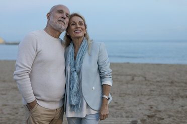 Spain, Barcelona, happy senior couple on the beach at dusk - MAUF02258