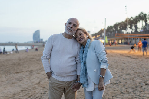 Spanien, Barcelona, glückliches älteres Paar am Strand in der Abenddämmerung - MAUF02263