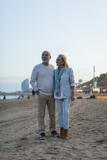 Spanien, Barcelona, glückliches älteres Paar am Strand in der Abenddämmerung - MAUF02265